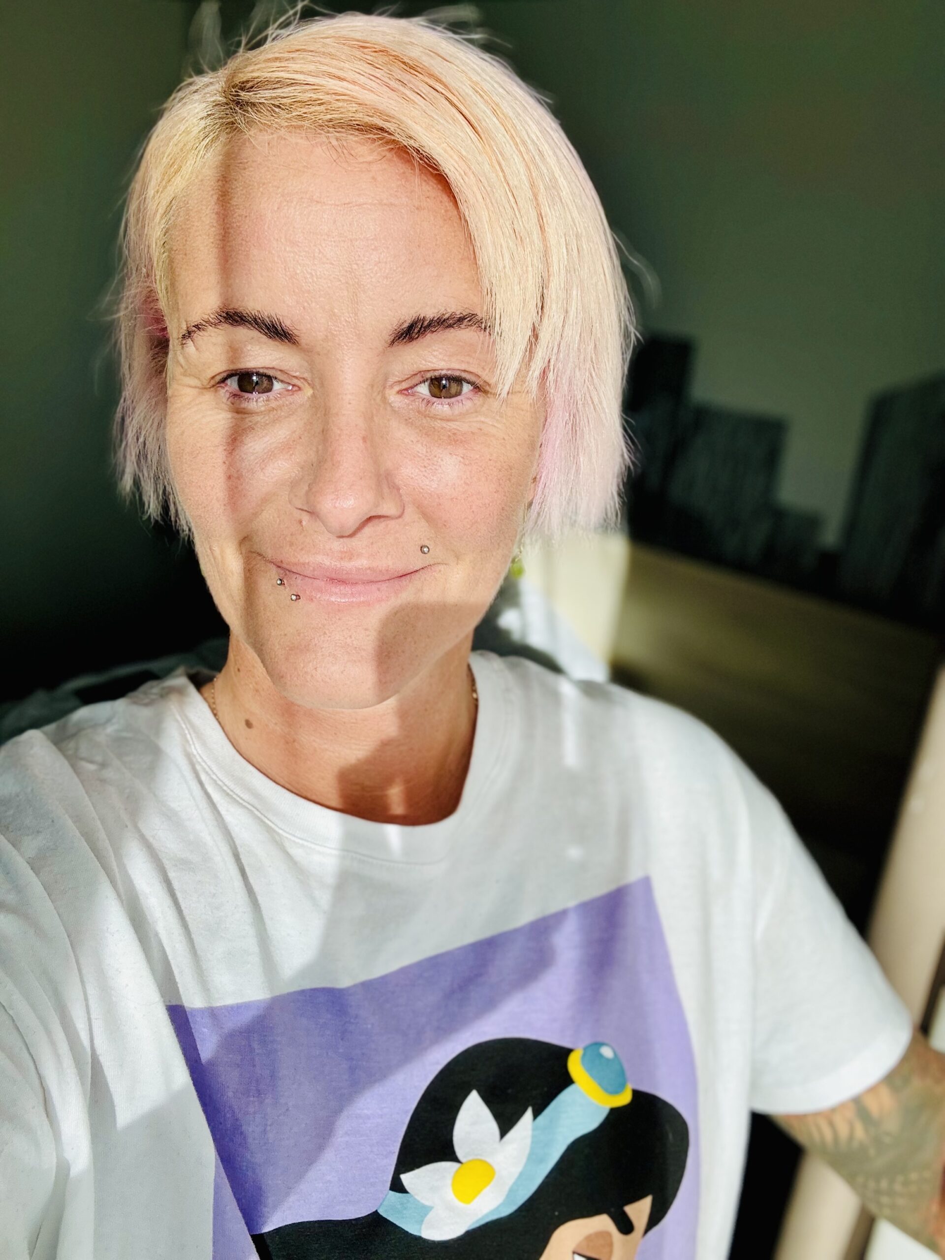 Nika Brunet smiling portrait with pink hair and Disney Jasmine t-shirt